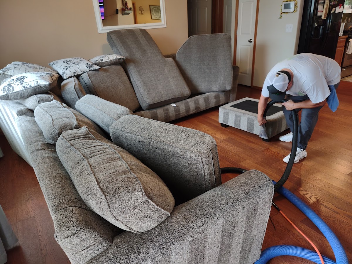 Cleaning Machine technician steam cleaning upholstery in a Tri-Cities home